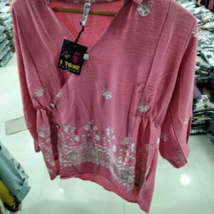 Women's rose pink top with white floral embroidery on the hem and a cinched waist.