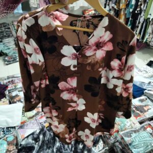 Women's terracotta brown blouse with large pink and white cherry blossom floral print.