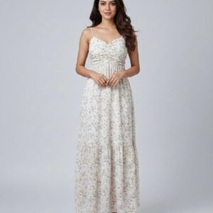 Woman wearing a white sleeveless maxi dress with a light pink and green floral print, featuring a ruched sweetheart neckline.