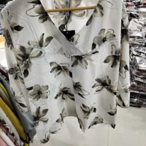 Women's ivory V-neck top with grey floral print and white lace trim detail.