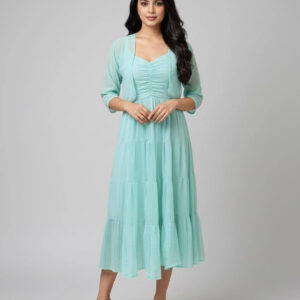 Woman wearing an aqua mint tiered midi dress with a matching sheer three-quarter sleeve shrug.